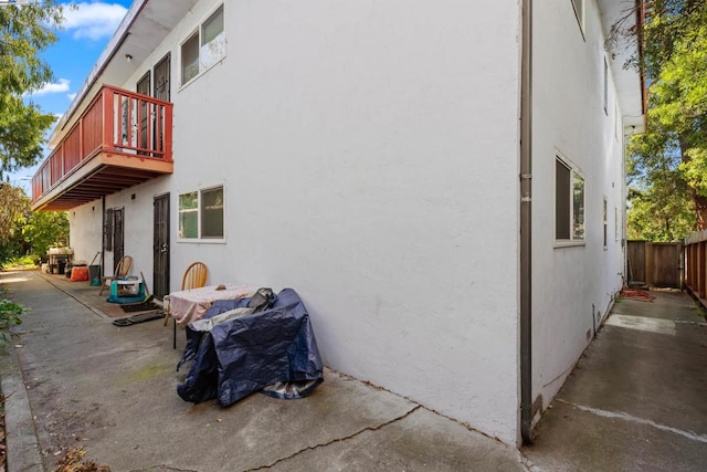 view of home's exterior featuring a balcony and a patio