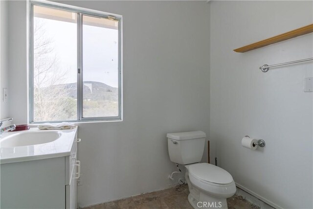 bathroom with toilet, a mountain view, plenty of natural light, and vanity