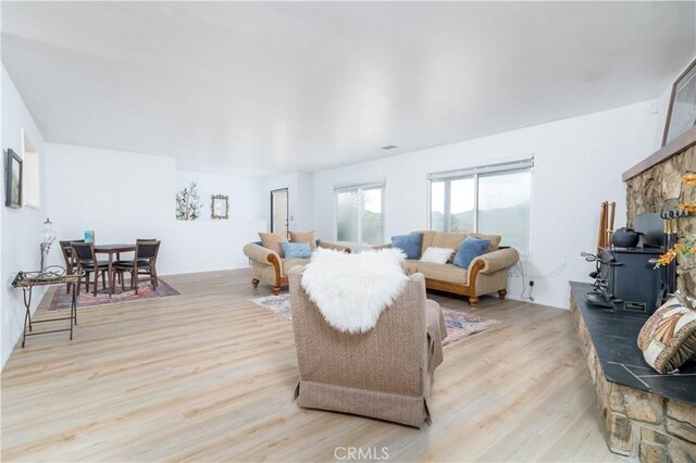 living room featuring a wood stove and light hardwood / wood-style floors