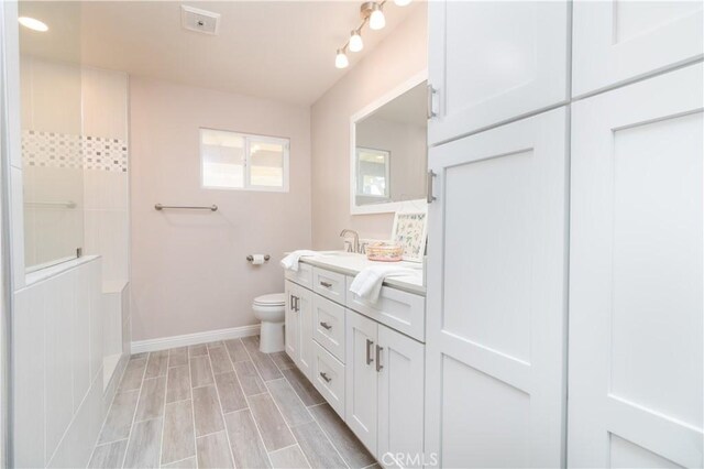 bathroom featuring toilet, vanity, and wood-type flooring