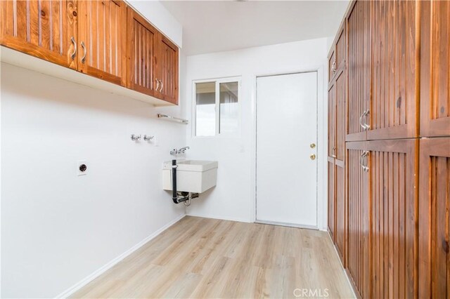 washroom featuring cabinets, light hardwood / wood-style floors, and hookup for an electric dryer