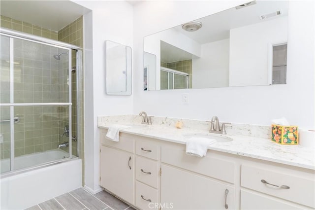 bathroom featuring vanity and combined bath / shower with glass door