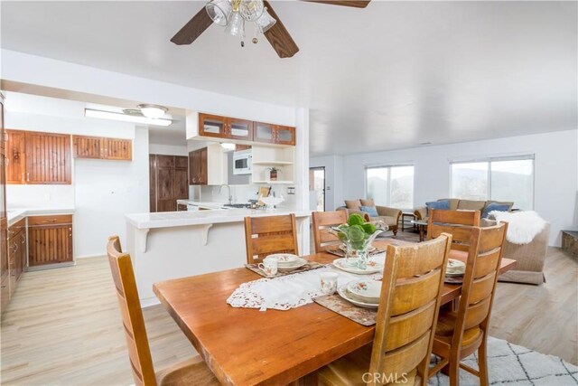 dining space featuring light hardwood / wood-style floors, sink, and ceiling fan