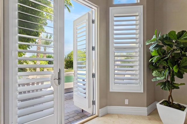 doorway to outside with light tile patterned flooring