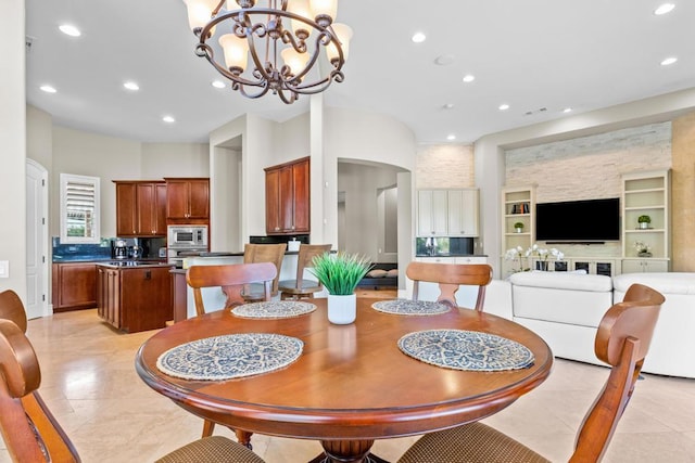 dining space featuring light tile patterned flooring, a chandelier, and built in features