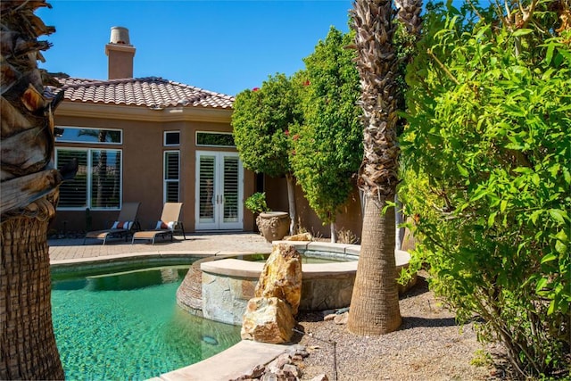 rear view of property with french doors and a patio area