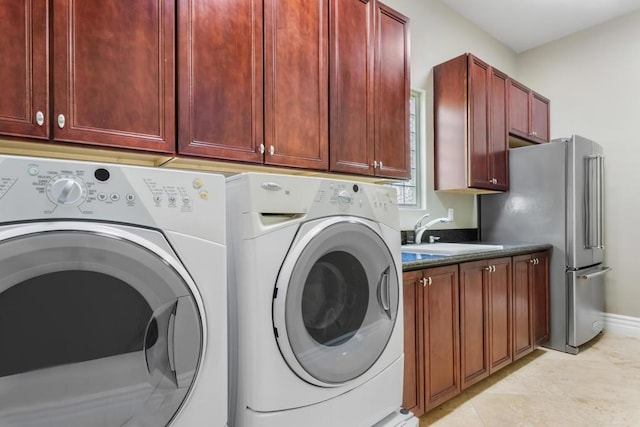 clothes washing area featuring cabinets, washing machine and dryer, sink, and light tile patterned floors