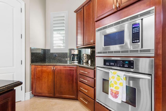 kitchen featuring dark stone countertops, light tile patterned floors, tasteful backsplash, and appliances with stainless steel finishes