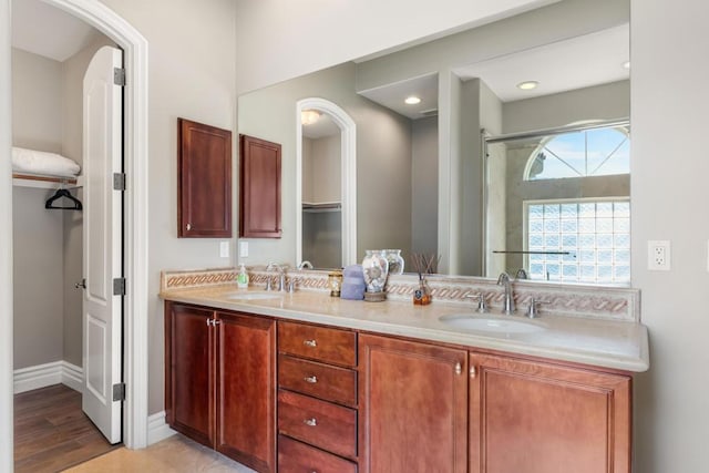 bathroom featuring vanity, wood-type flooring, and a shower with shower door