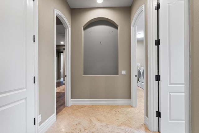 hall featuring light tile patterned flooring and washer and clothes dryer