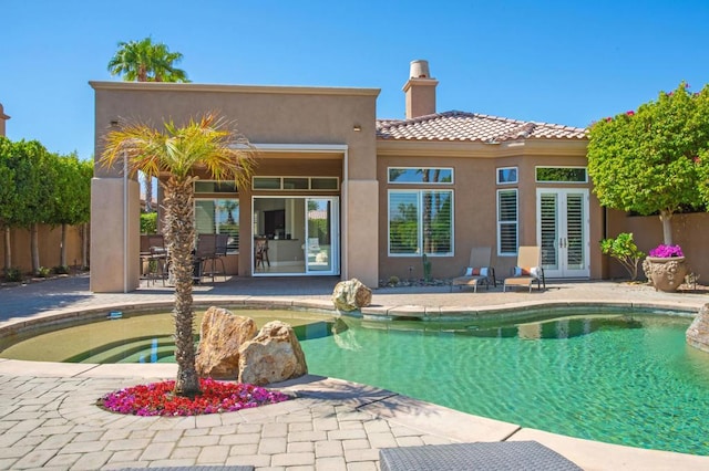 back of house with french doors, a fenced in pool, and a patio area