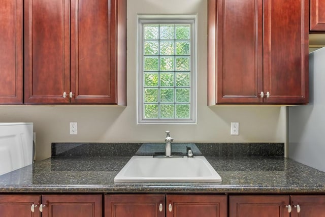 kitchen featuring sink and dark stone countertops