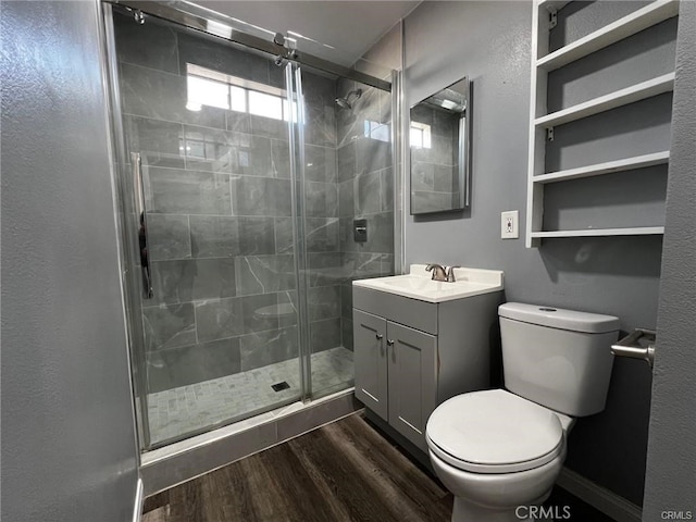 bathroom with wood-type flooring, toilet, a shower with door, and vanity