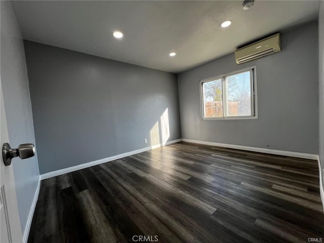 empty room featuring dark hardwood / wood-style flooring and a wall mounted air conditioner