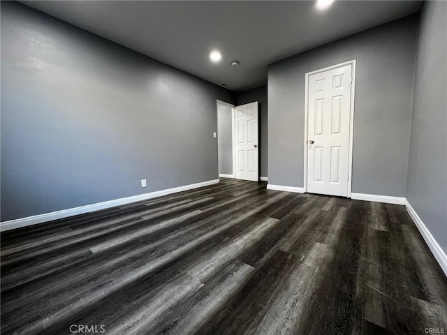 empty room with dark hardwood / wood-style flooring