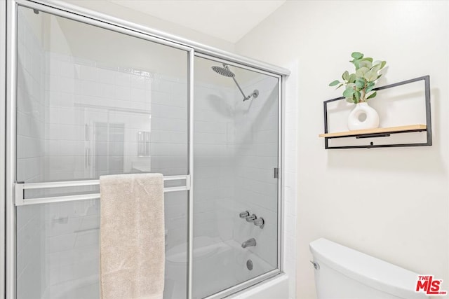 bathroom with toilet and shower / bath combination with glass door