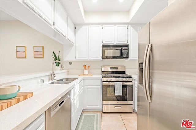 kitchen featuring white cabinets, sink, stainless steel appliances, and light tile patterned flooring