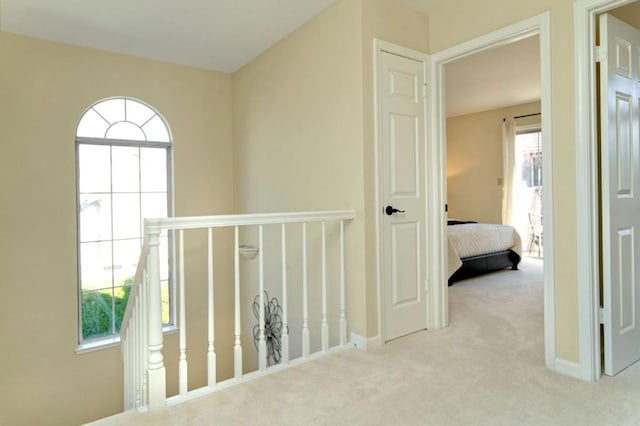 corridor featuring light colored carpet