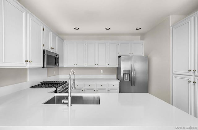 kitchen featuring appliances with stainless steel finishes, sink, and white cabinetry