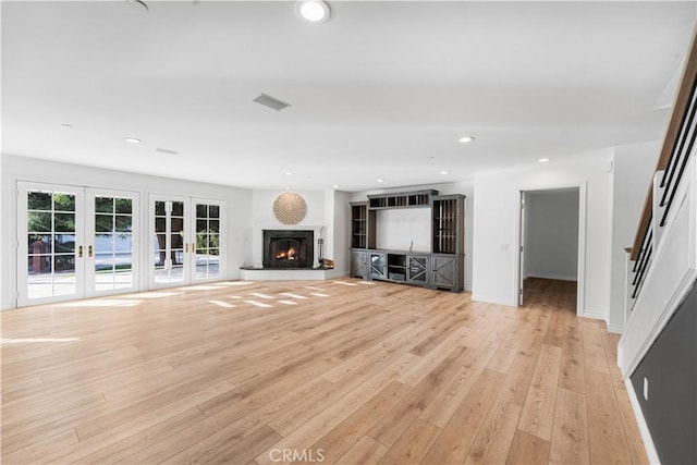 unfurnished living room with light hardwood / wood-style flooring and french doors