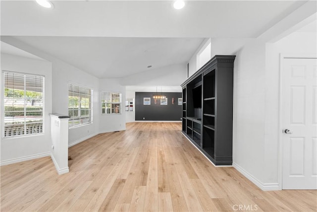 interior space featuring a chandelier, light hardwood / wood-style floors, and vaulted ceiling