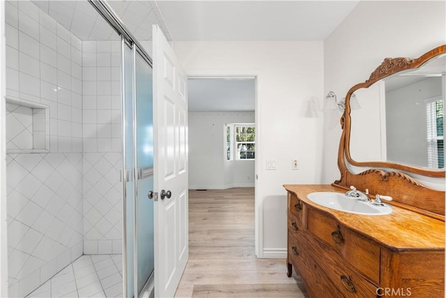 bathroom featuring a shower with door, vanity, and hardwood / wood-style flooring