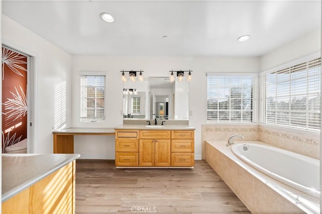 bathroom featuring vanity, hardwood / wood-style floors, and tiled bath