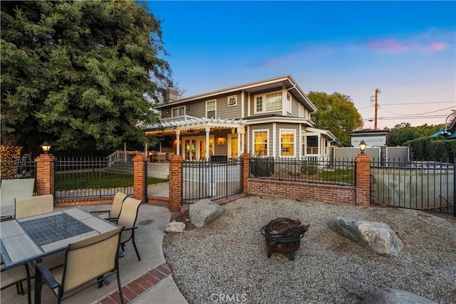 back house at dusk with a patio and a fire pit