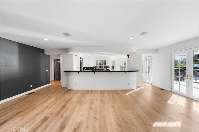 unfurnished living room with french doors and light hardwood / wood-style flooring