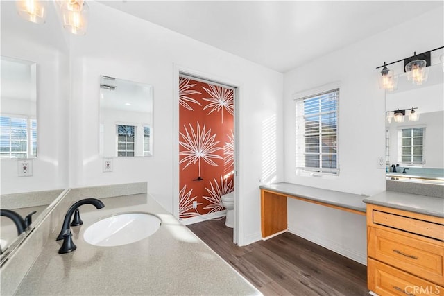 bathroom featuring vanity, toilet, hardwood / wood-style floors, and a wealth of natural light