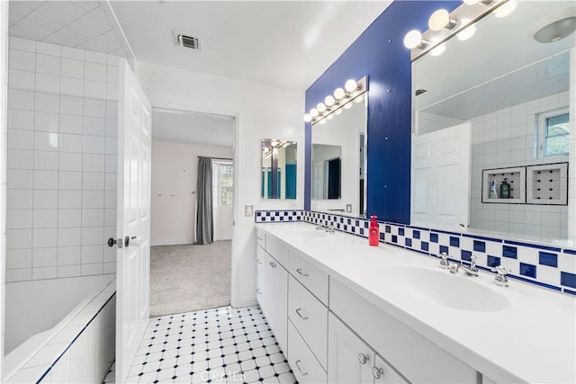 bathroom with tasteful backsplash and vanity