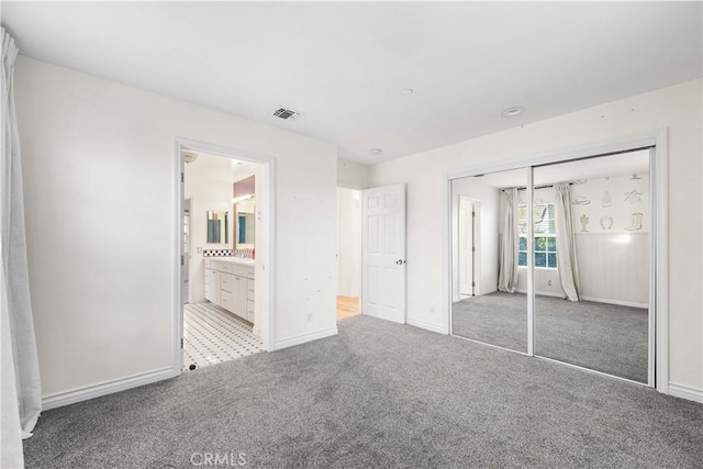 unfurnished bedroom featuring carpet floors, connected bathroom, and a closet