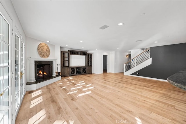 living room with a fireplace and light wood-type flooring