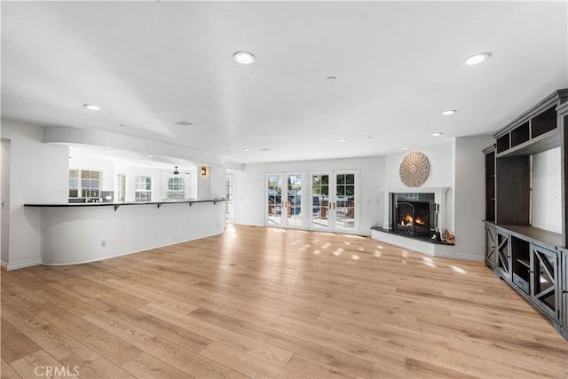 unfurnished living room with light hardwood / wood-style floors and french doors