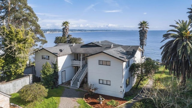 view of front of property with a water view and a balcony