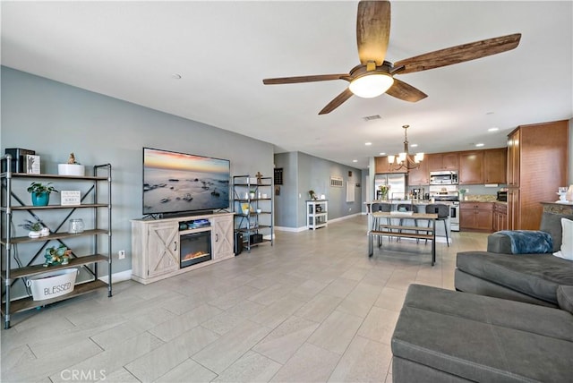 living room featuring ceiling fan with notable chandelier