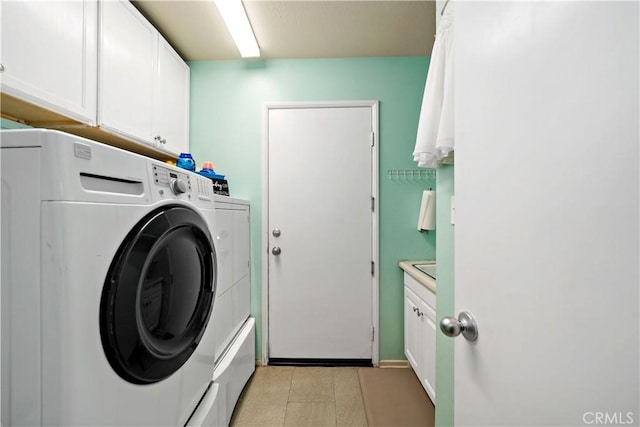 washroom featuring cabinets and washing machine and clothes dryer