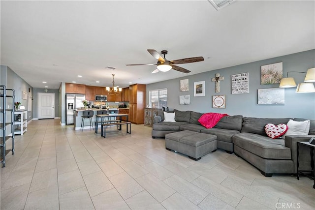 living room featuring ceiling fan with notable chandelier