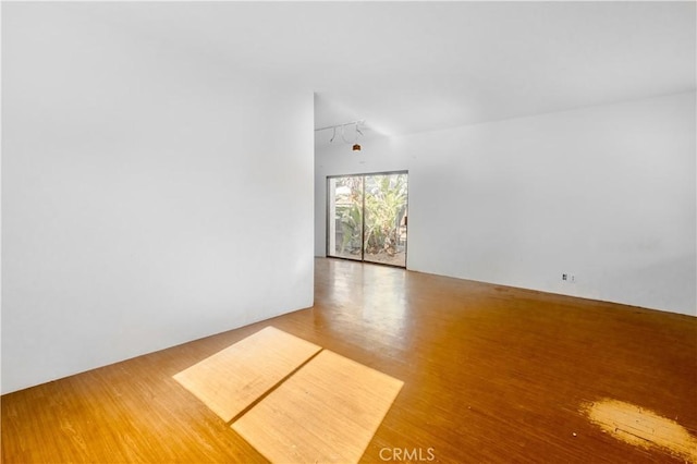 unfurnished living room featuring wood-type flooring and rail lighting