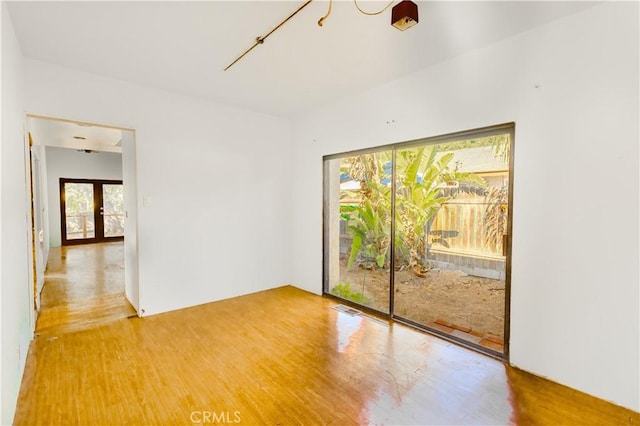 empty room featuring french doors and hardwood / wood-style floors