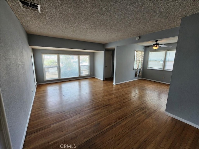 unfurnished living room featuring hardwood / wood-style flooring, plenty of natural light, and ceiling fan