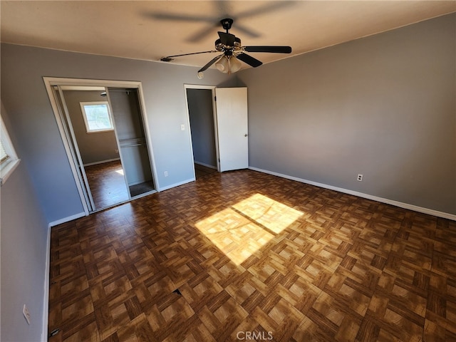 unfurnished bedroom with ceiling fan and dark parquet flooring