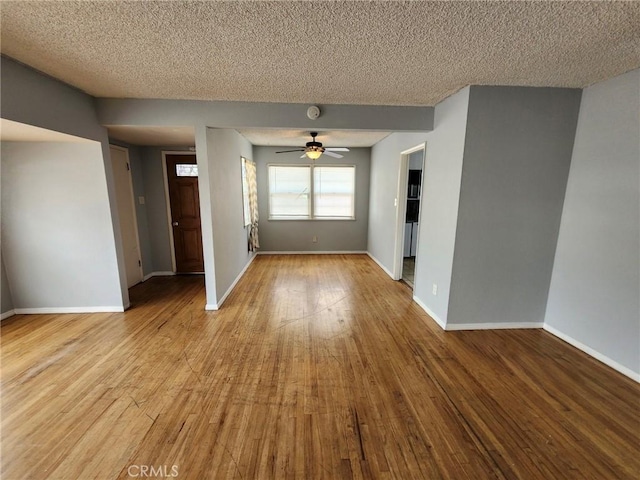 empty room with ceiling fan, a textured ceiling, and light hardwood / wood-style flooring