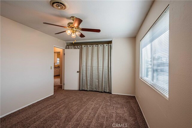 unfurnished bedroom featuring ceiling fan and carpet