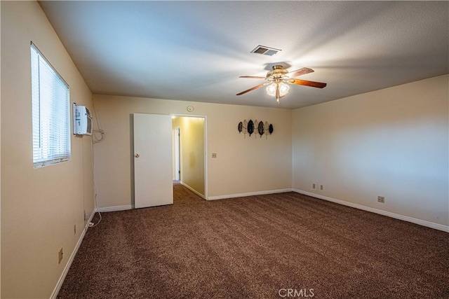 carpeted spare room featuring a wall unit AC and ceiling fan