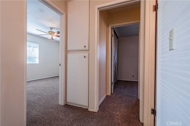 corridor featuring dark colored carpet