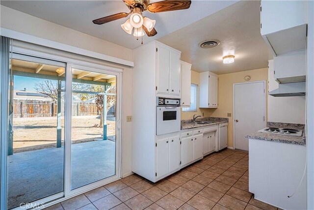 kitchen featuring light tile patterned floors, sink, white appliances, and white cabinetry