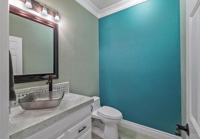 bathroom featuring toilet, crown molding, and vanity