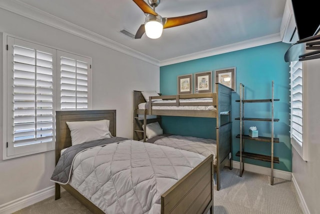 carpeted bedroom featuring ceiling fan and ornamental molding