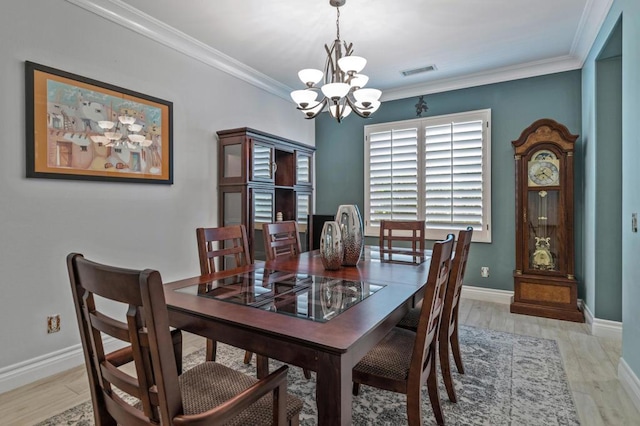 dining area featuring an inviting chandelier, crown molding, and light wood-type flooring